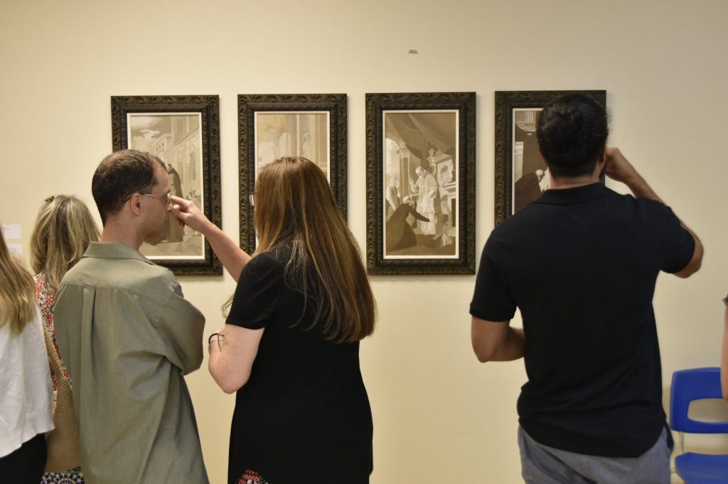 Attendees look at Br Ted's four paintings from the life of St Philip