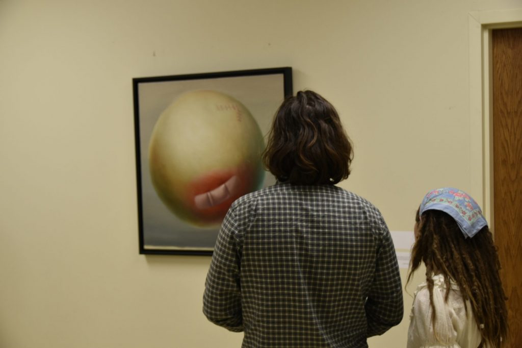 Attendees ponder art by Lezsek Wyczolkowski