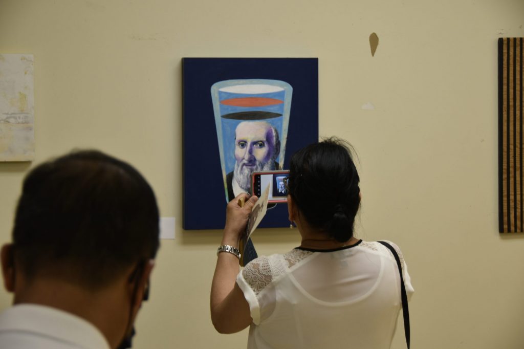 An attendee snaps a photo of a new painting of St Philip by Ale Groen